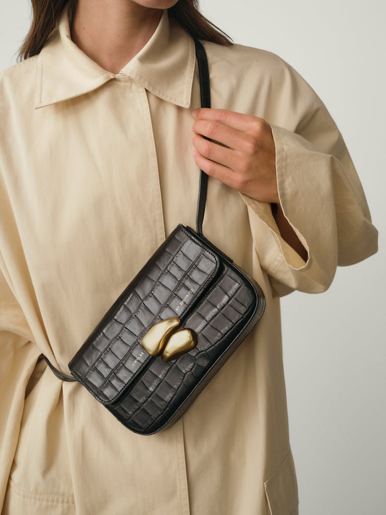 Flap Bag with Sculptural Seal “glossy black crocodile”